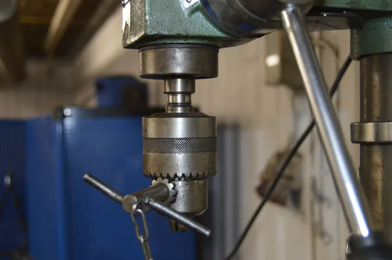 Close-up of a drill press in a Swedish workshop, showcasing industrial machinery