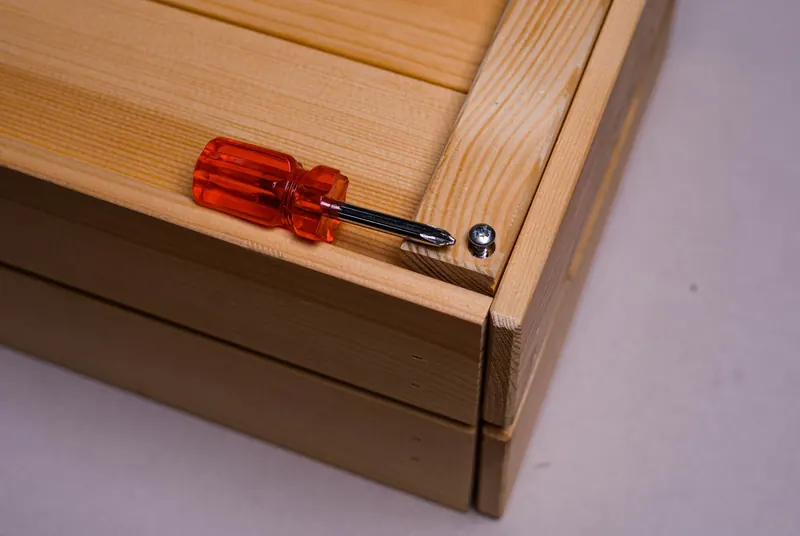 Detailed shot of a screwdriver and screw on wood, showcasing tool precision